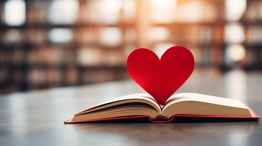 Dating a Writer Close up of a red heart in between pages of an open paper book resting on a table inside a library